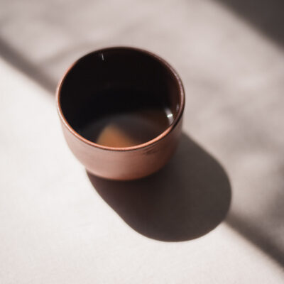 handmade ceramic coffee or tea cup in brown clay