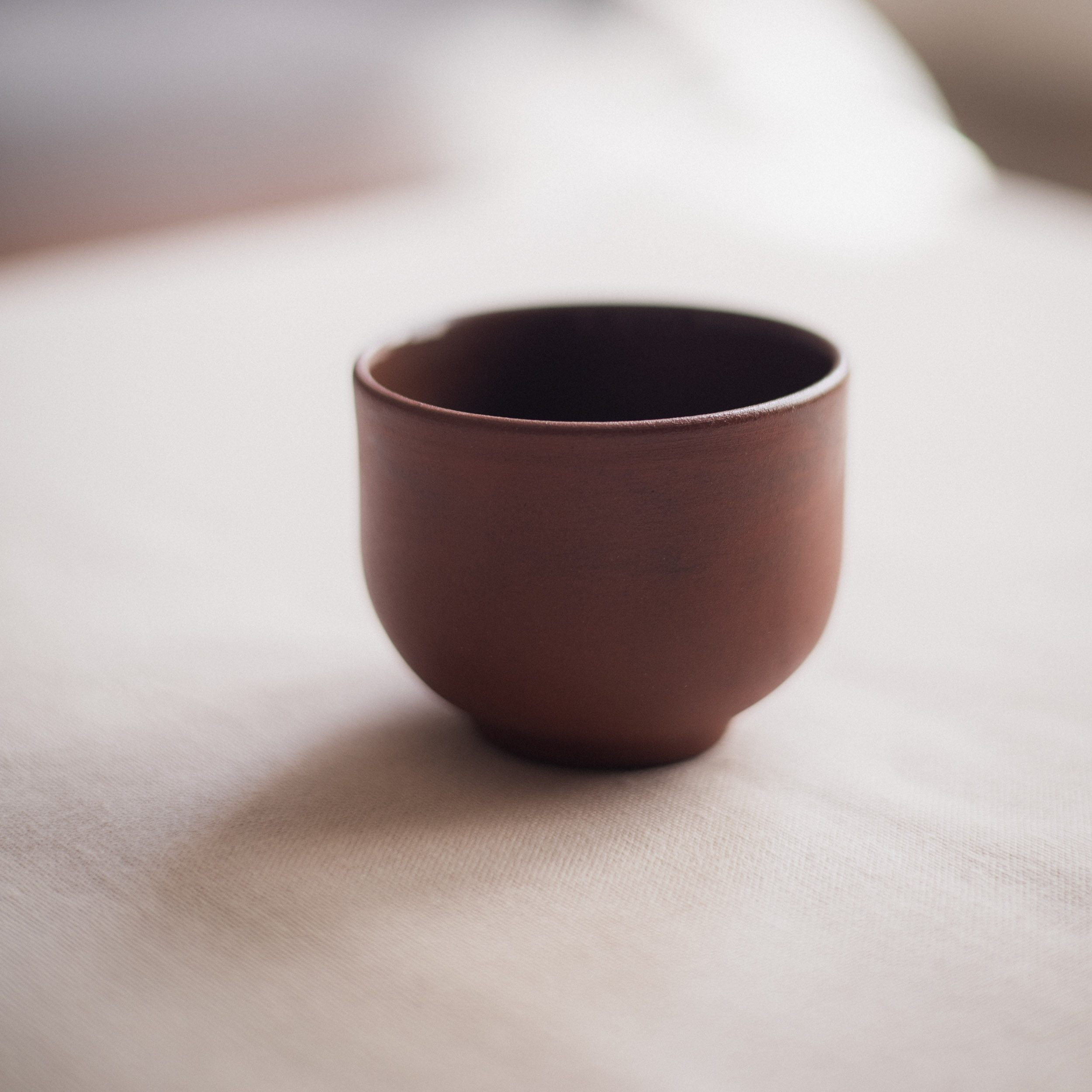 handmade ceramic coffee or tea cup in brown clay