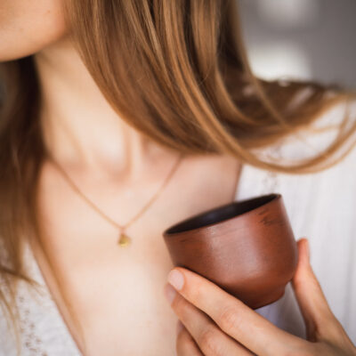 handmade ceramic coffee or tea cup in brown clay